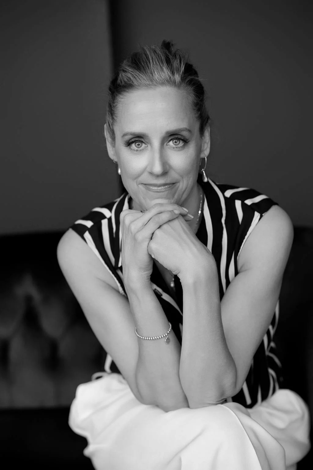 Laura Burkey seated against a dark studio background